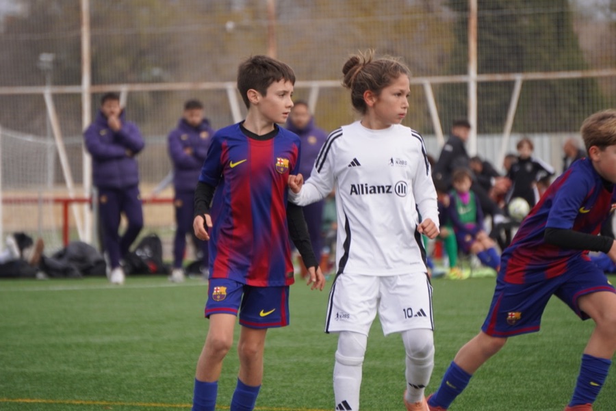 Jugador de Forms marca a su par frente a un rival de academia en un partido juvenil en Madrid